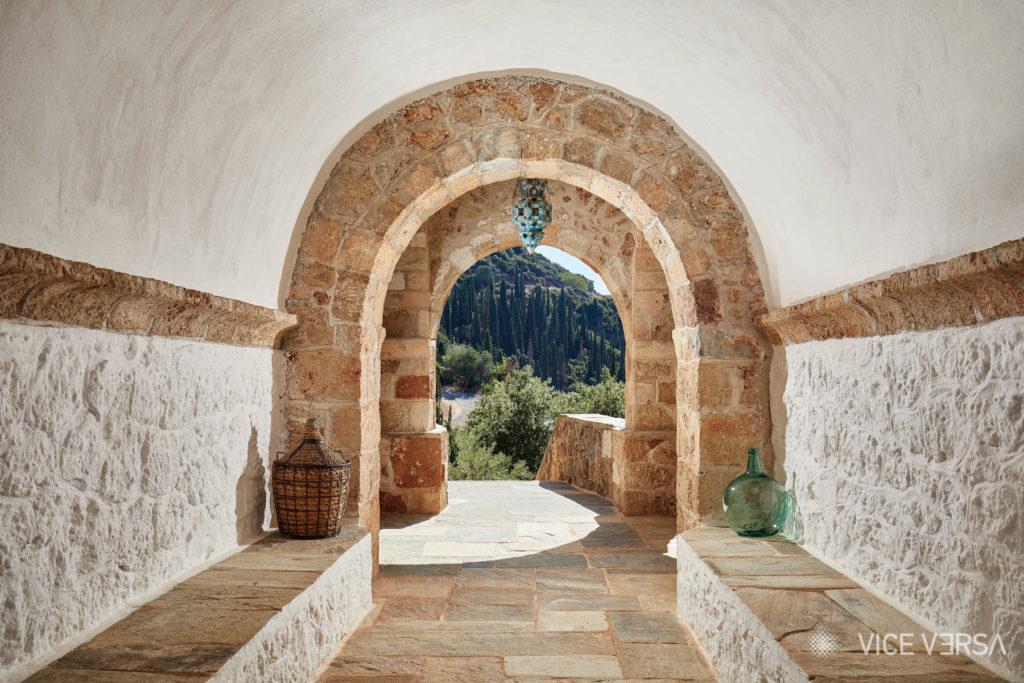 Stone arched corridor and cypress trees at Leigh Fermor House Kardamili