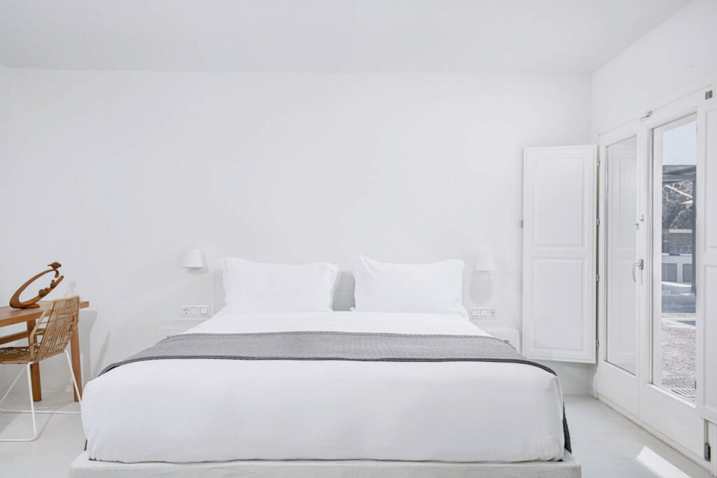 Minimal white guest room interior at Nafsika Estate Santorini