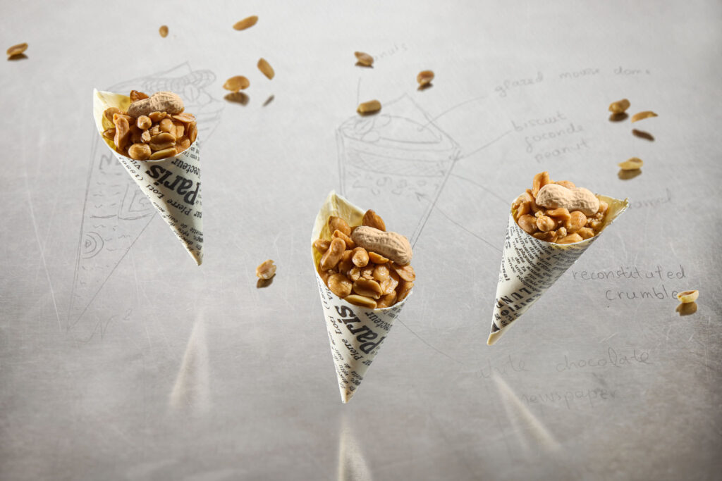 Creative pastry composition with floating Peanuts on the Go cones