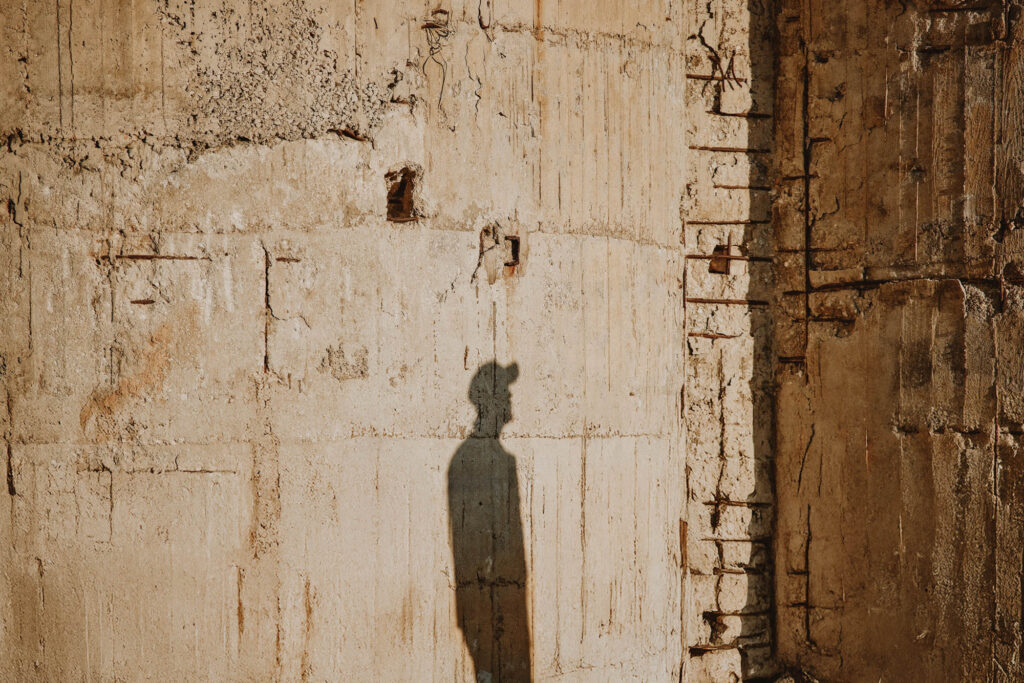 Creative shadow portrait of Nicolas Nikolakopoulos against a concrete wall