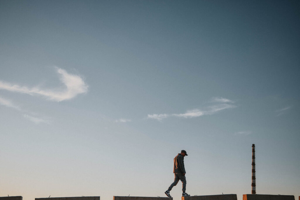 Nicolas Nikolakopoulos walking through the industrial landscape of Drapetsona