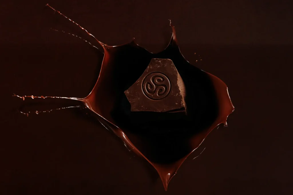 Callebaut chocolate block splashing into liquid chocolate