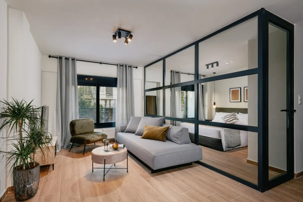 Living room with bedroom behind glass partition panels