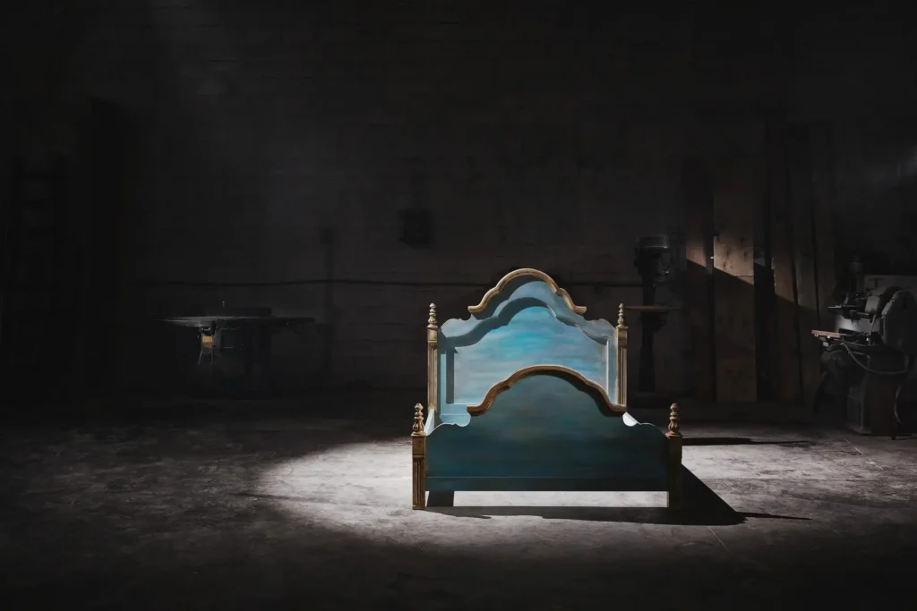 Handmade Anama Deco bed displayed in a low key furniture workshop