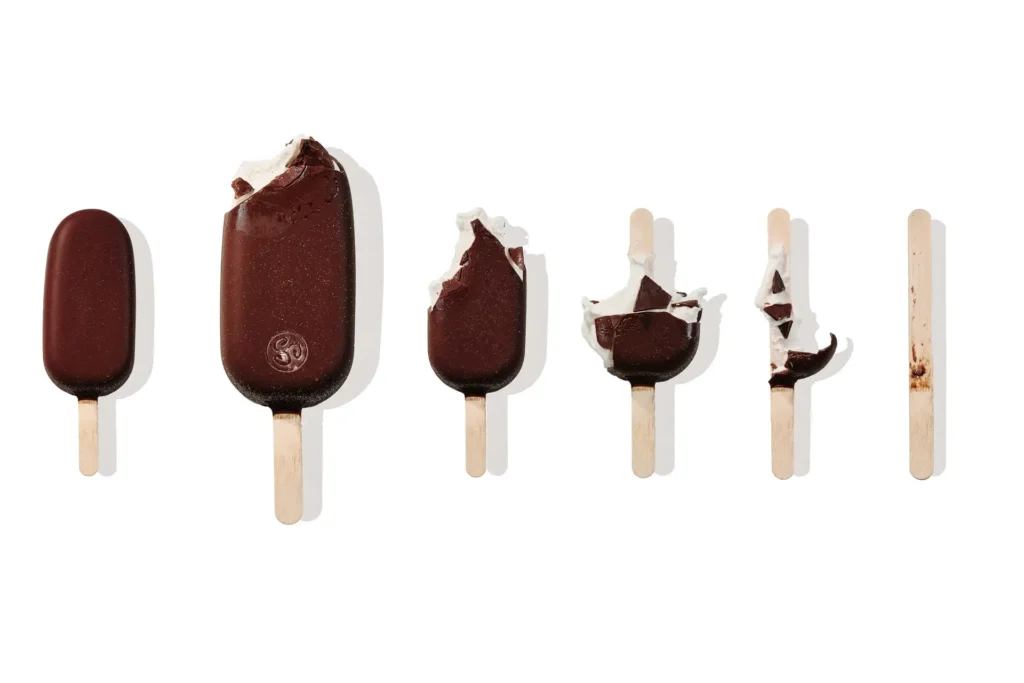 Creative ice cream stick composition showing stages from full bar to wooden stick
