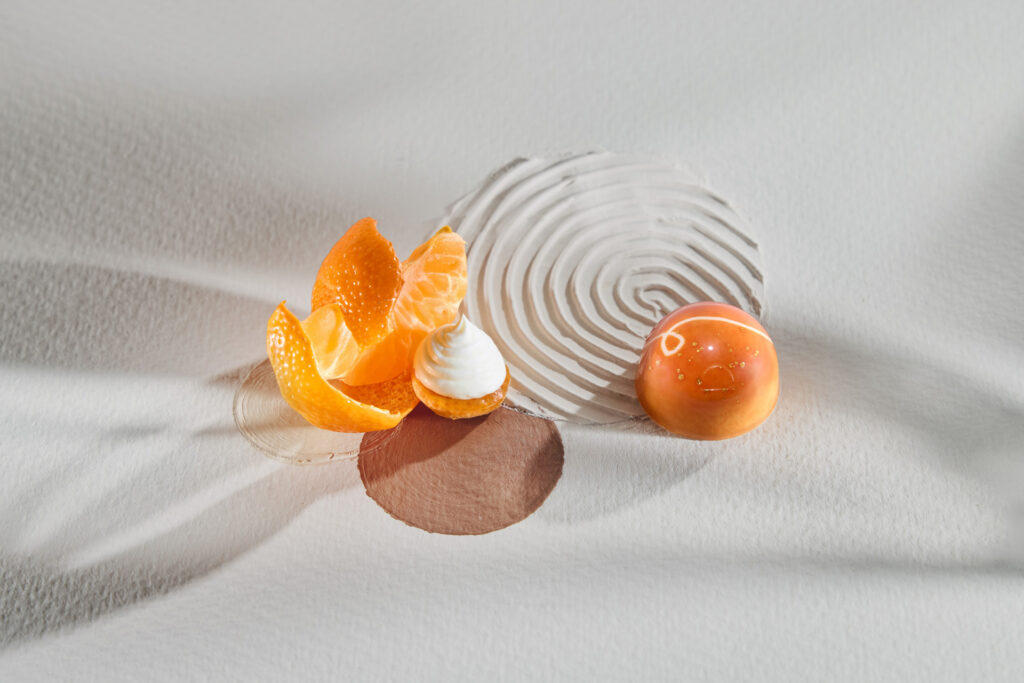 Tangerine and yoghurt PRALINZ bonbon with styled ingredients