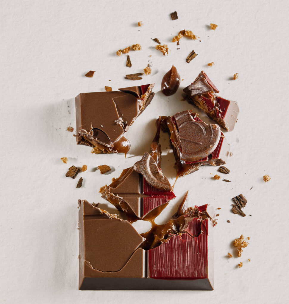 Cracked PRALINZ chocolate bonbon revealing caramel filling and layers