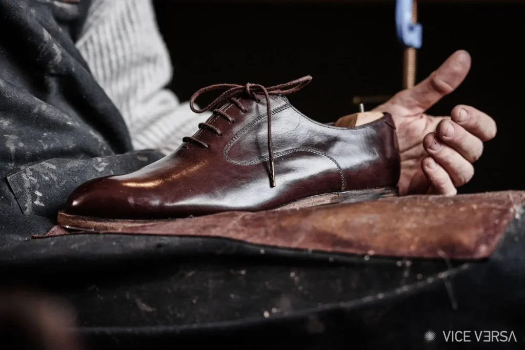 finishing touches by shoemaker on leather shoe