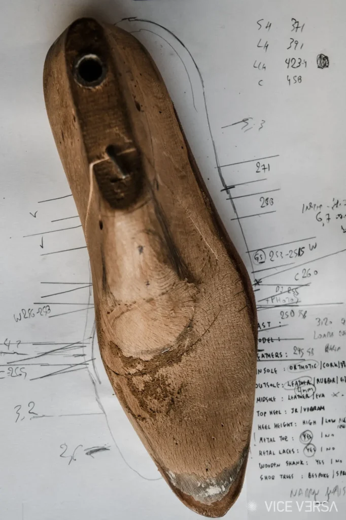 wooden shoe last with sketch pad beneath it