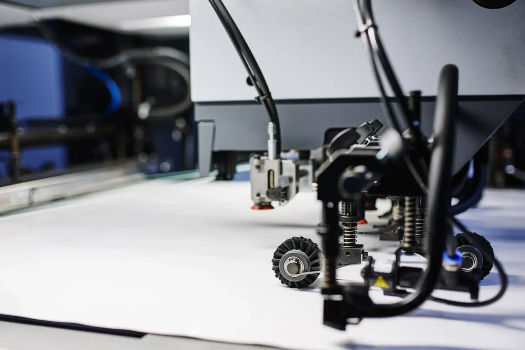 Close-up of sheet-feeding wheels and suction components inside a printing machine