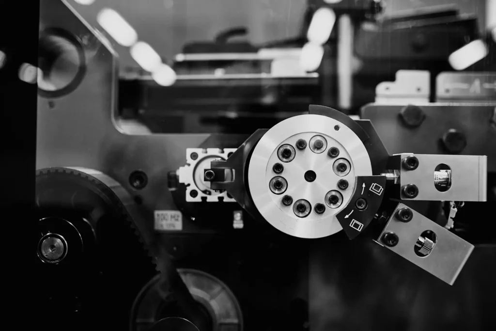 Corporate photography for printing facilities showing a black-and-white close-up of a circular machine component