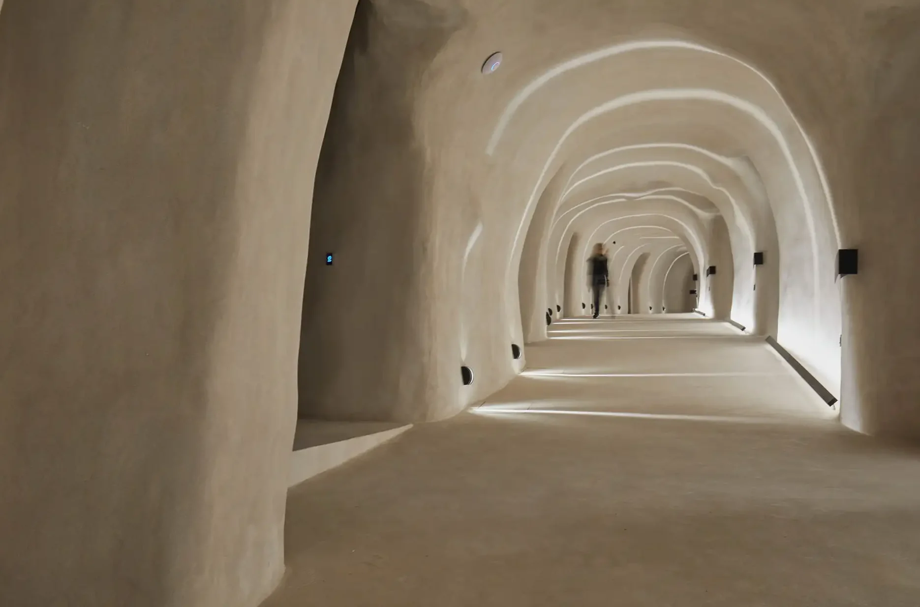 Divine Cave Santorini corridor interior with blurred guest figure