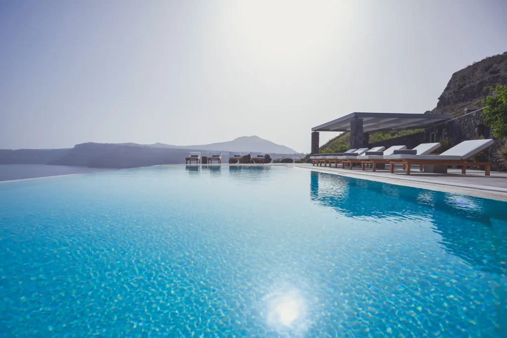 Water-level view of the pool at Akrotiri Private Residence with Santorini in the background