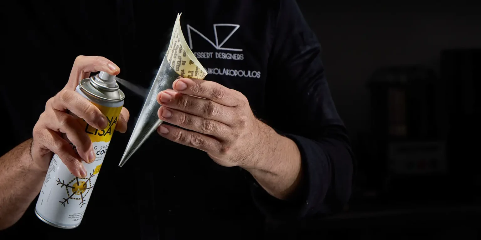 NIcolas Nikolakopoulos spraying a peanut cone to make chocolate stable