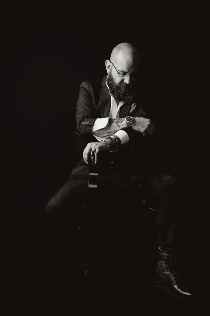 Black-background portrait of Yannis Manikis focused on expression and detail