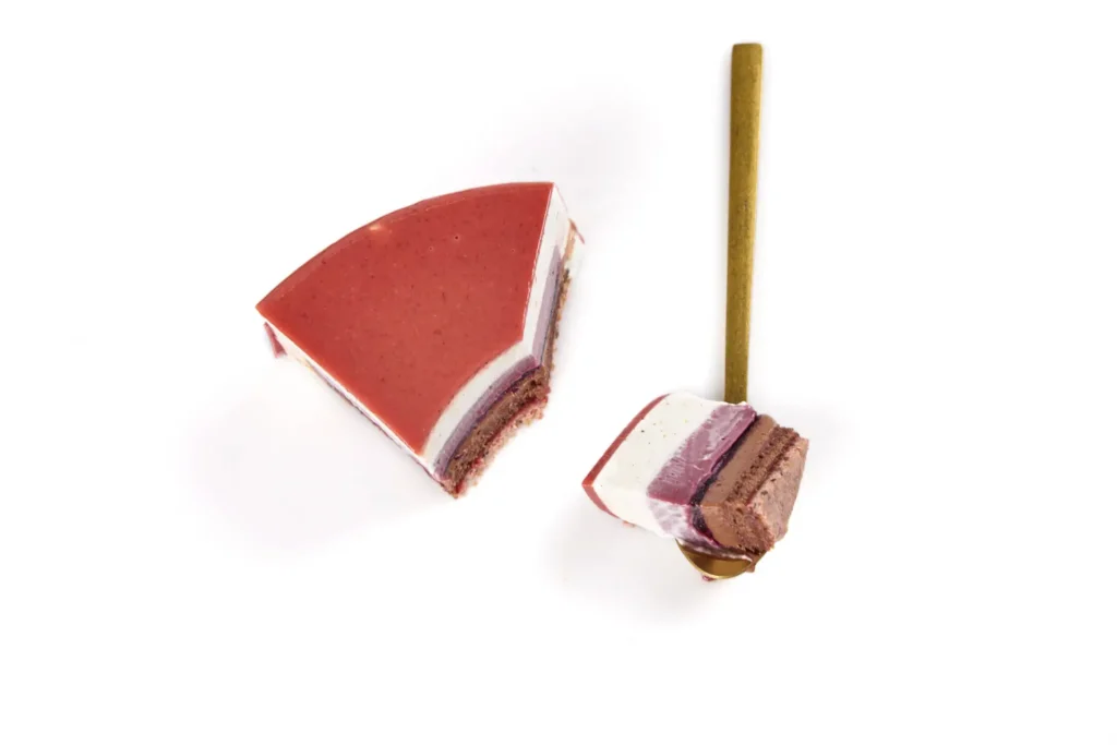 Geometric pastry composition with spoon breaking the symmetry