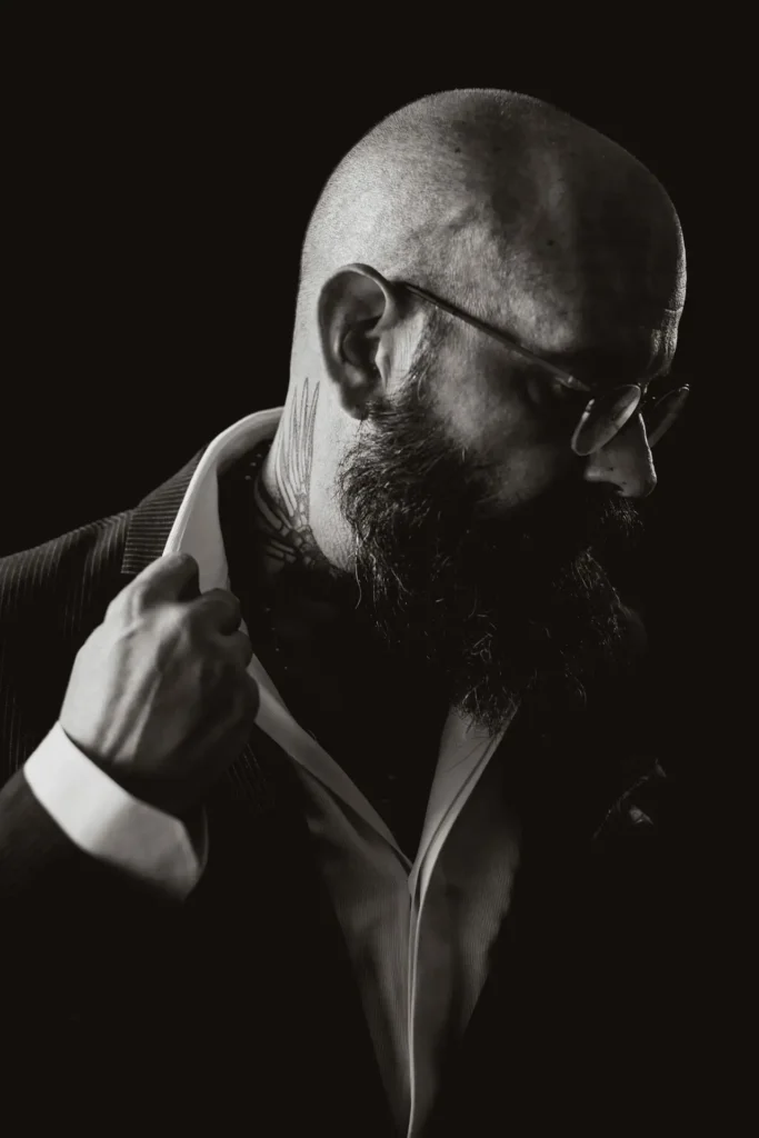 Studio portrait of Yannis Manikis revealing tattoo details