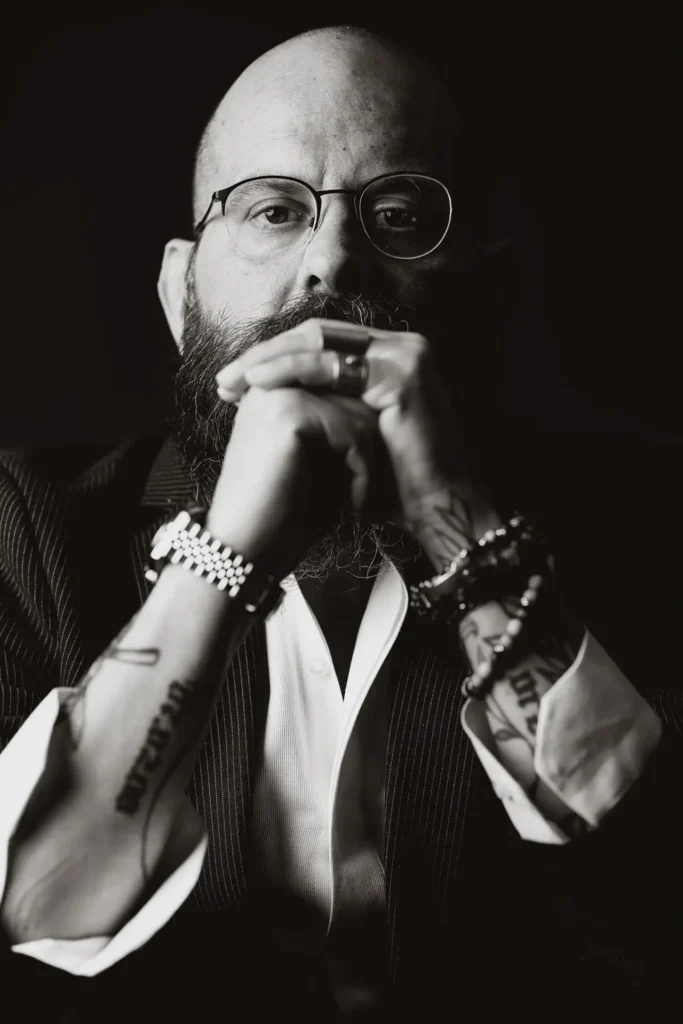 Dark studio portrait of Yannis Manikis focusing on his eyes and expression