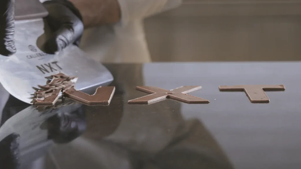 Creative concept breaking NXT chocolate letters with spatula for slow motion video